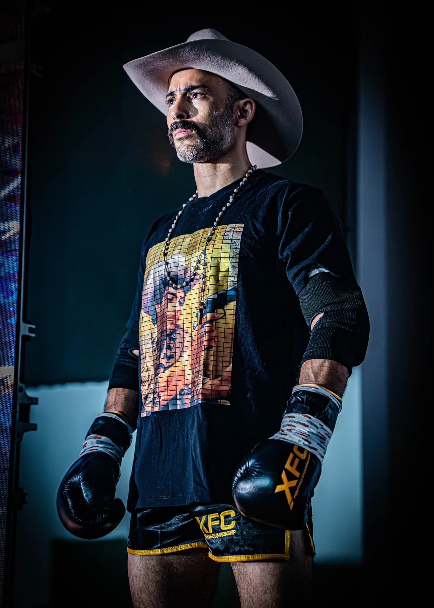 XFC fighter in a cowboy hat standing in a dramatic walkout portrait.