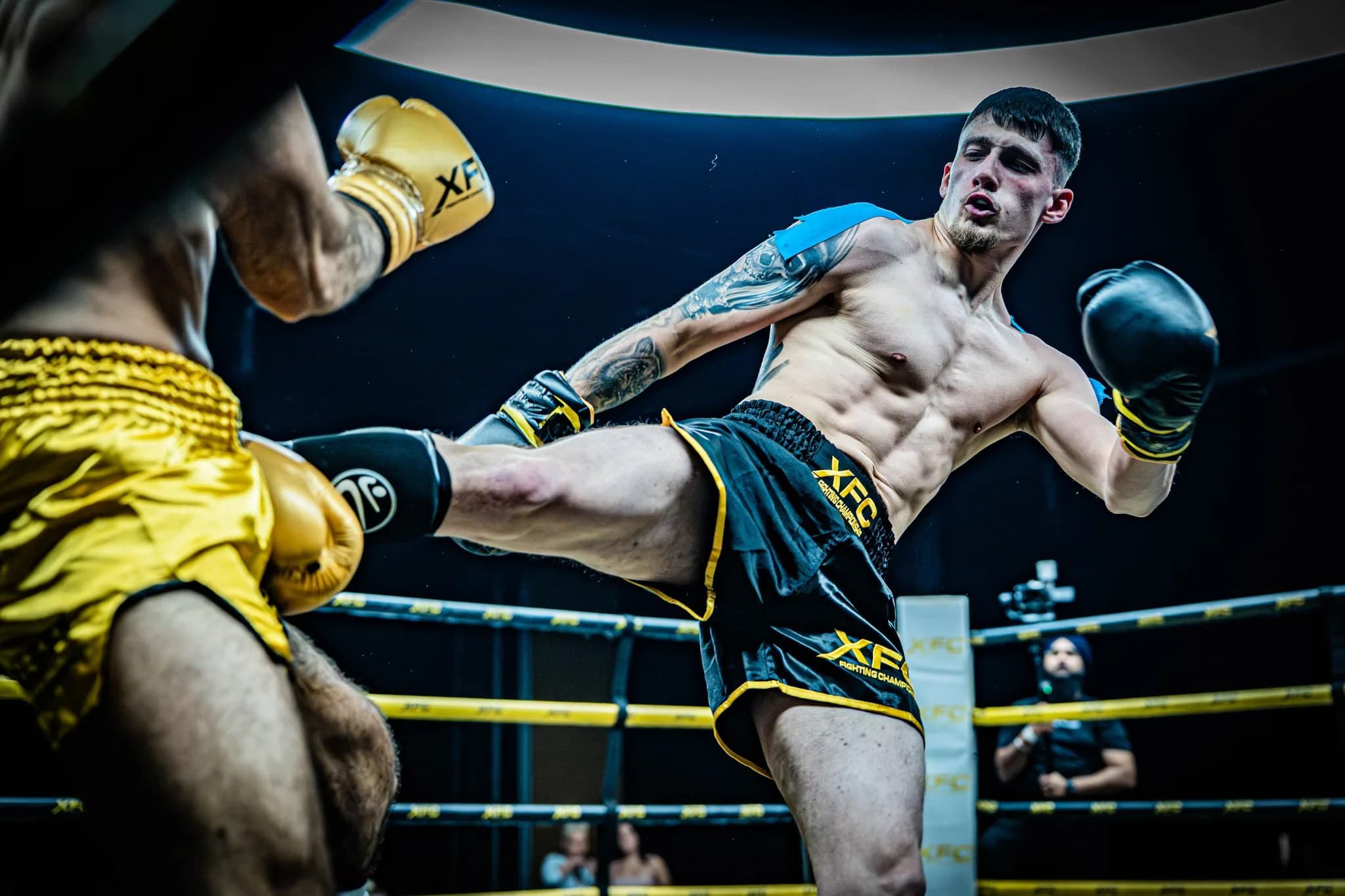 Ringside XFC image of a fighter landing a low kick under dramatic arena lighting.