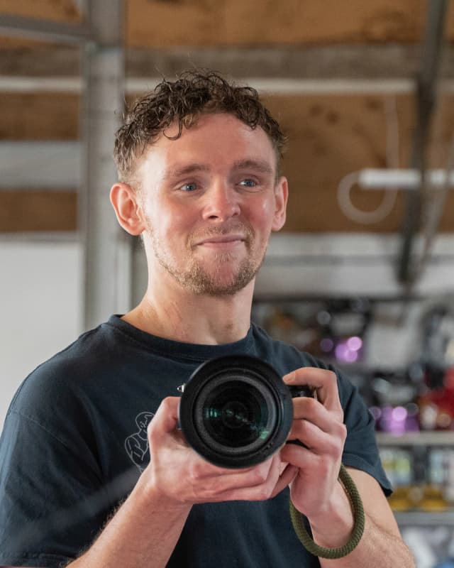 Luke Bolstridge holding a camera, founder and lead photographer, Nottingham.