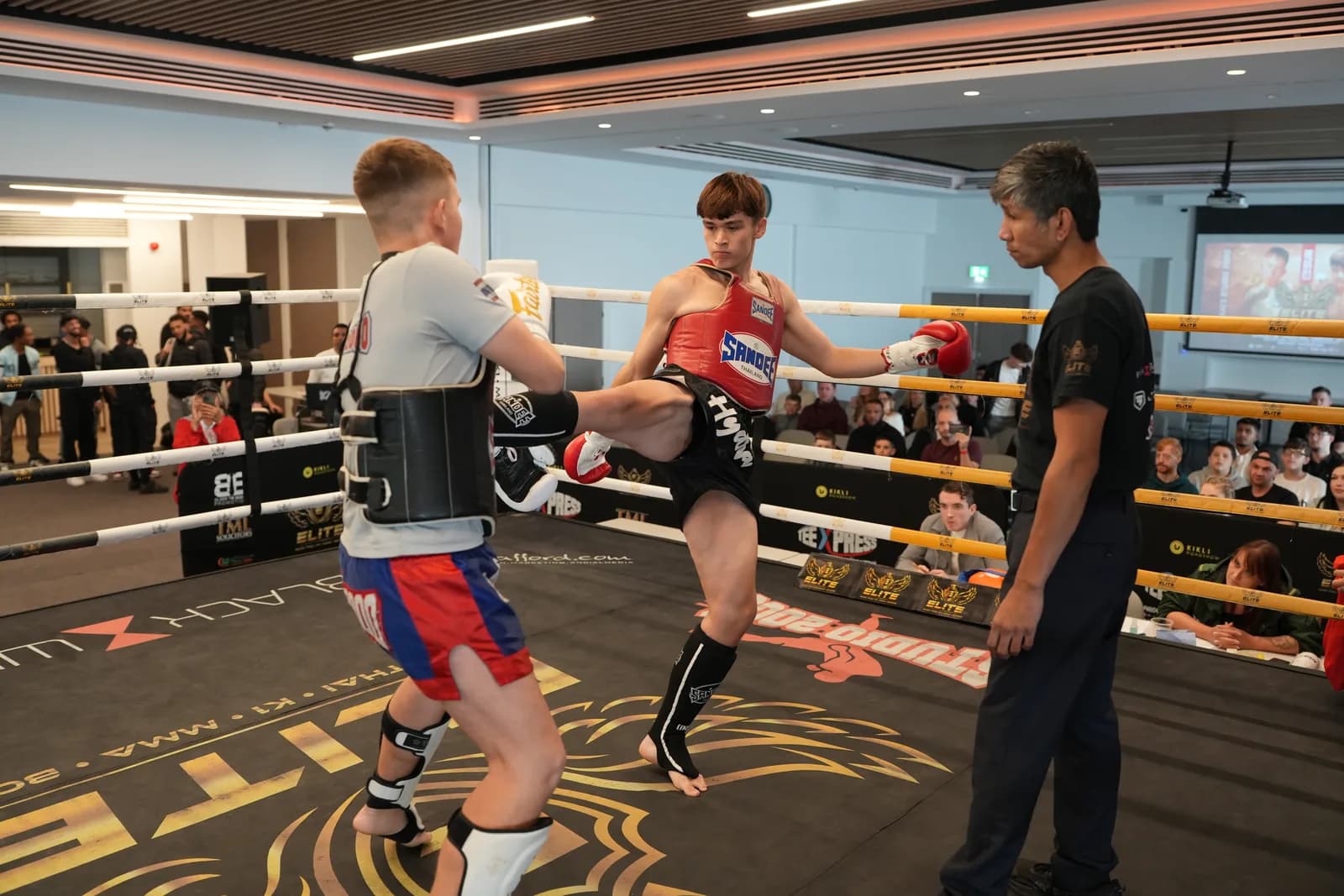Wide XFC image of two fighters trading kicks in the centre of the ring.