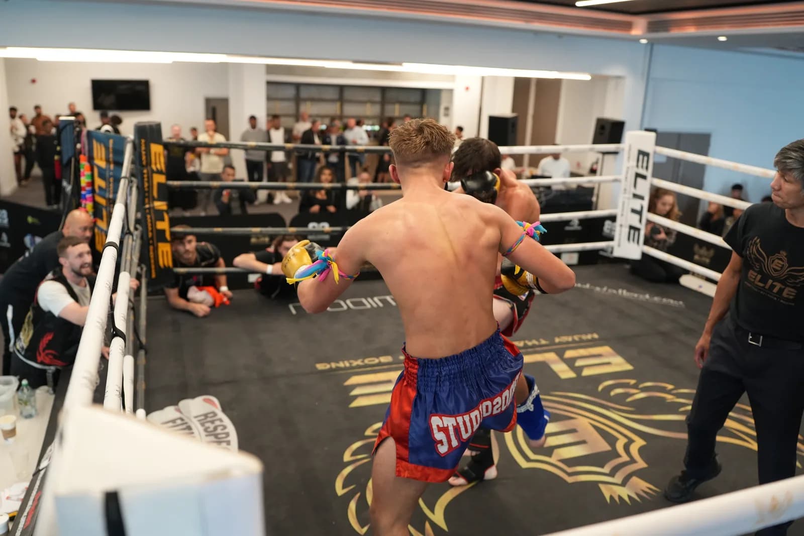 Wide XFC kickboxing image with ring branding, fighters, referee, and crowd context.