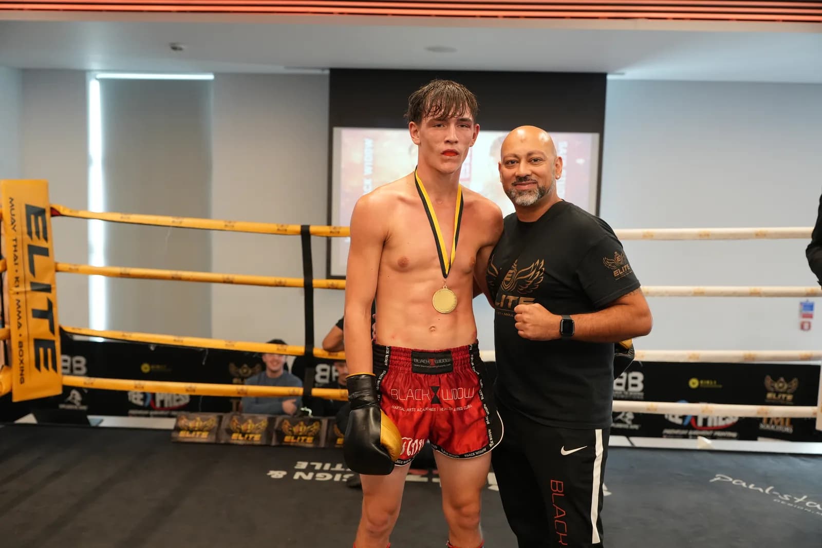 XFC post-fight winner portrait with medal and coach at ringside.
