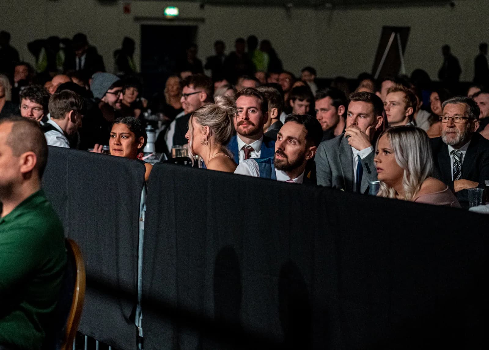 Crowd gathered behind a barrier during a busy live fight-night event.