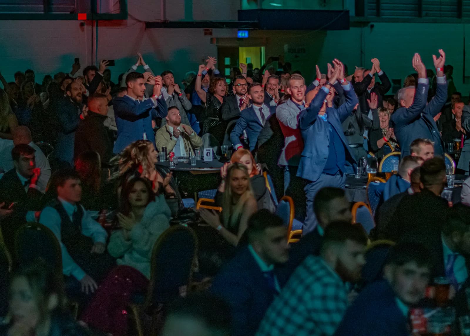 Wide crowd image from a packed live event with audience members reacting to the show.