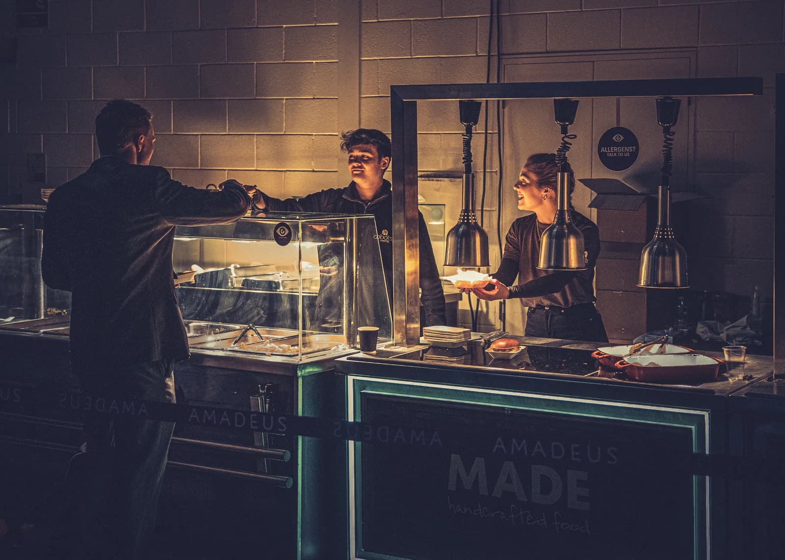 Candid event hospitality image of service at a lit bar during a live venue event.